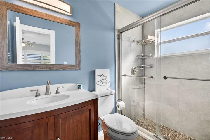 Bathroom with healthy amount of natural light, vanity, and a stall shower