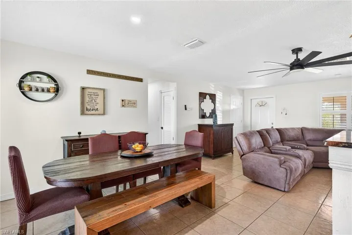 Dining area with light tile patterned floors, ceiling fan, and a textured ceiling