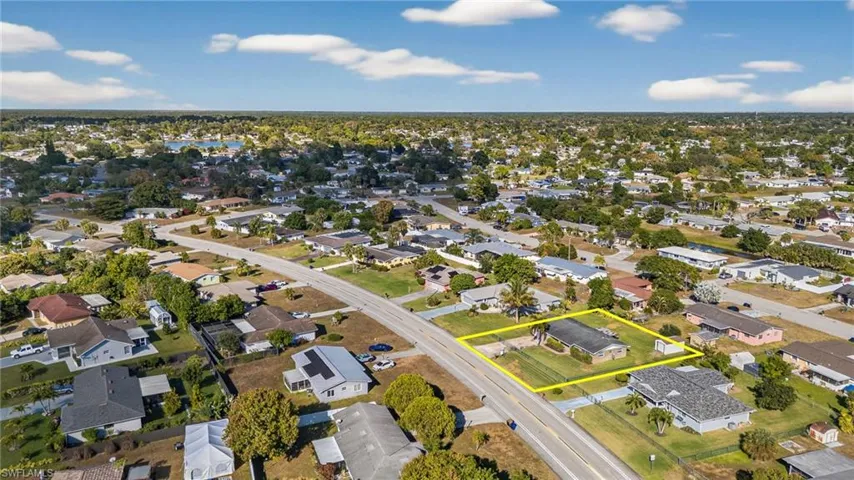 Aerial view of property and surrounding area with nearby suburban area