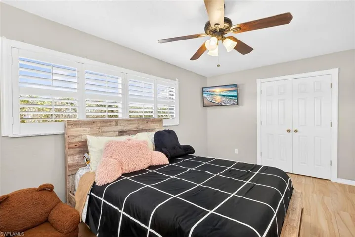Bedroom featuring light wood-style flooring, a closet, and ceiling fan
