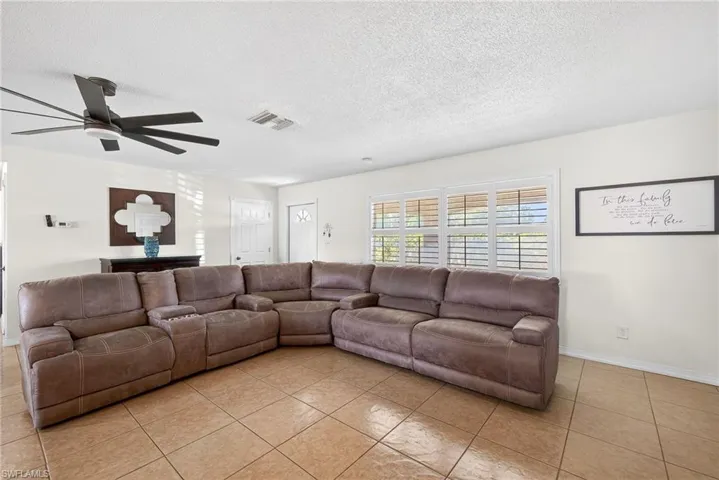 Tiled living area featuring a textured ceiling and ceiling fan