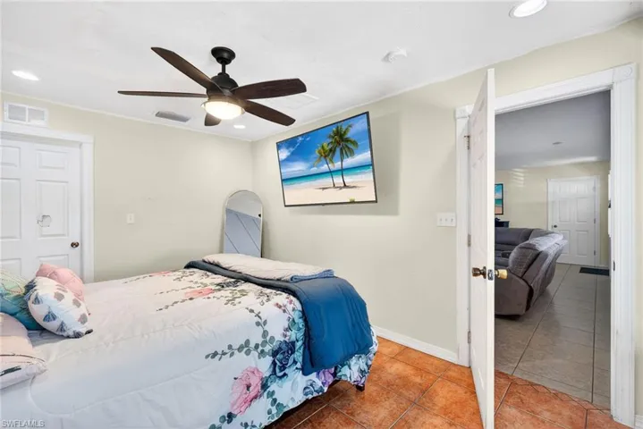 Tiled bedroom with recessed lighting and ceiling fan