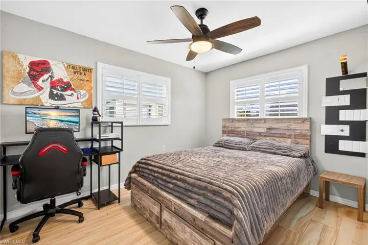 Bedroom featuring light wood-style flooring, ceiling fan, and a desk