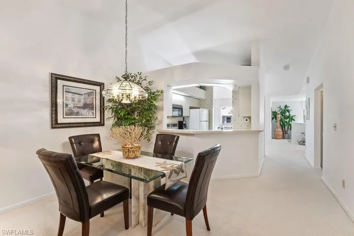 Dining/Living area featuring overhead chandelier lighting, and vaulted ceilings.