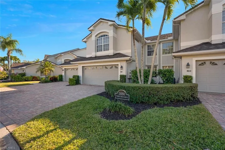 Traditional-style home with stucco siding, an attached garage, and decorative driveway
