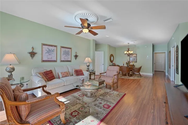 Living room featuring wood finished floors, a chandelier, and a ceiling fan