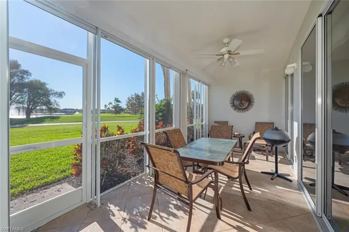 Sunroom featuring ceiling fan, outdoor dining space, and golf course view