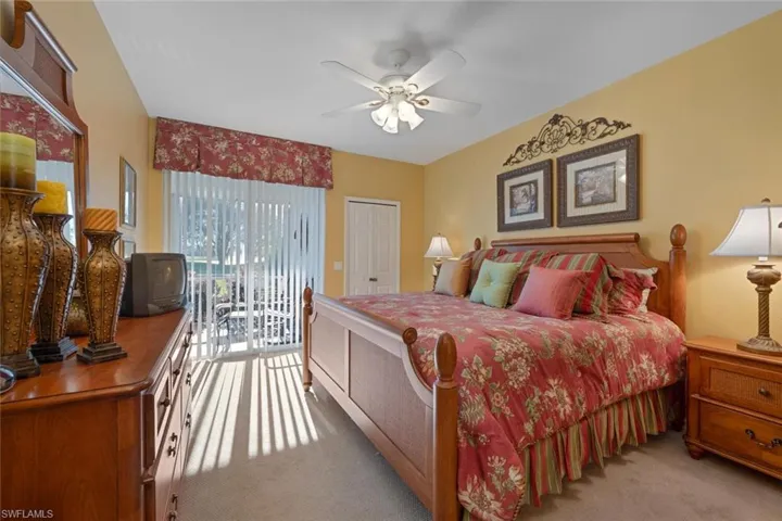 Bedroom with access to outside, light carpet, and a ceiling fan