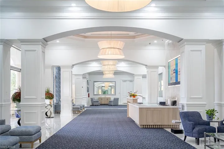Reception area featuring decorative columns, arched walkways, recessed lighting, a decorative wall, and a high ceiling