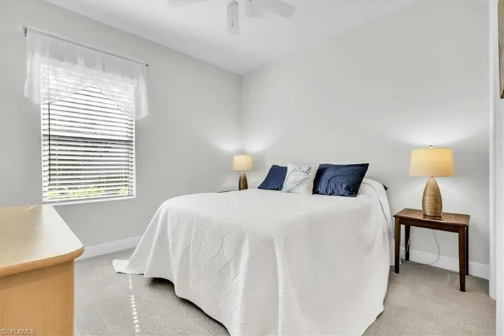 Carpeted room featuring a ceiling fan, a window with horizontal blinds, and neutral wall tones