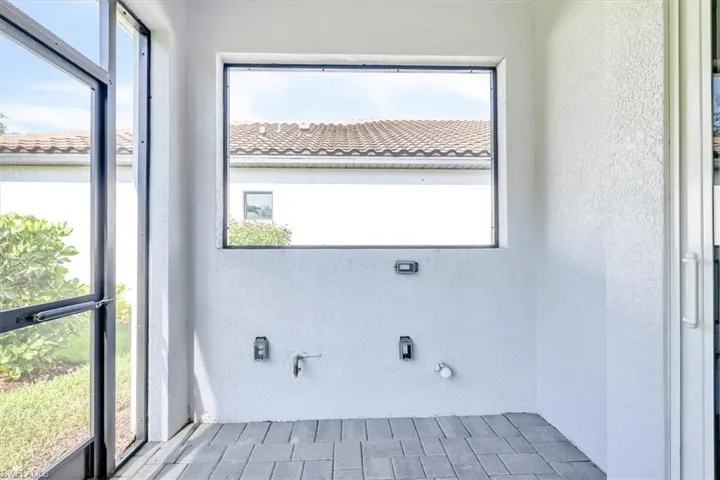 Screened outdoor area featuring paver flooring, a fixed window, and multiple wall outlets