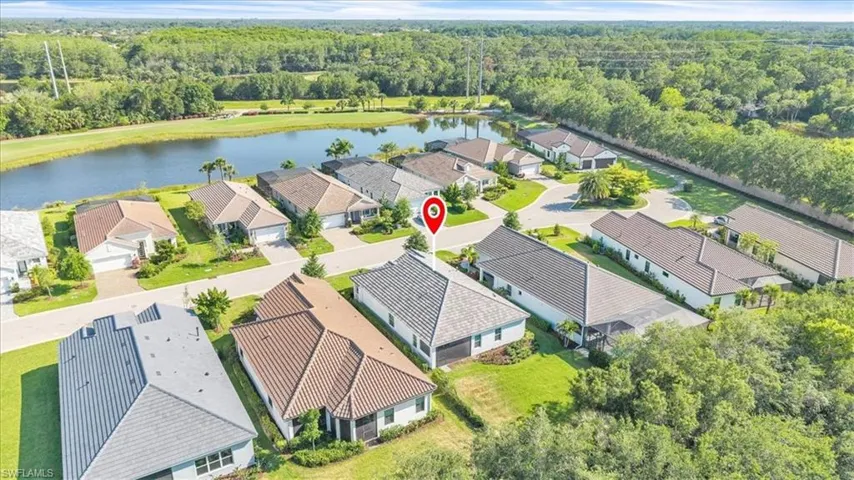 Aerial community overview featuring a cul-de-sac street, manicured lawns, and a large body of water bordering the property