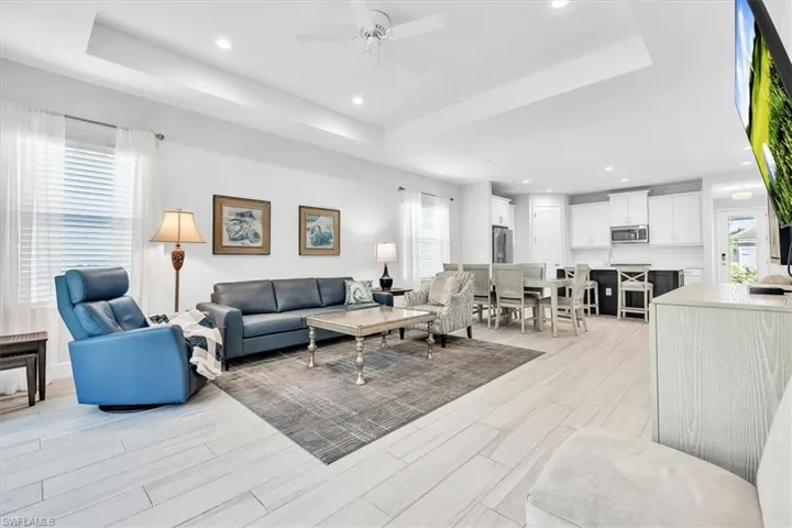 Open concept living area with light-toned wood-finish flooring, recessed lighting, and a ceiling fan