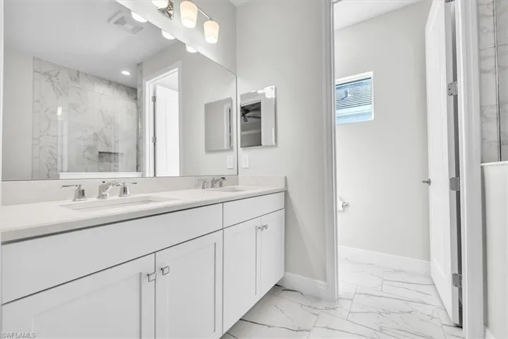 Dual vanity with undermount sinks, chrome faucets, and light-toned countertops