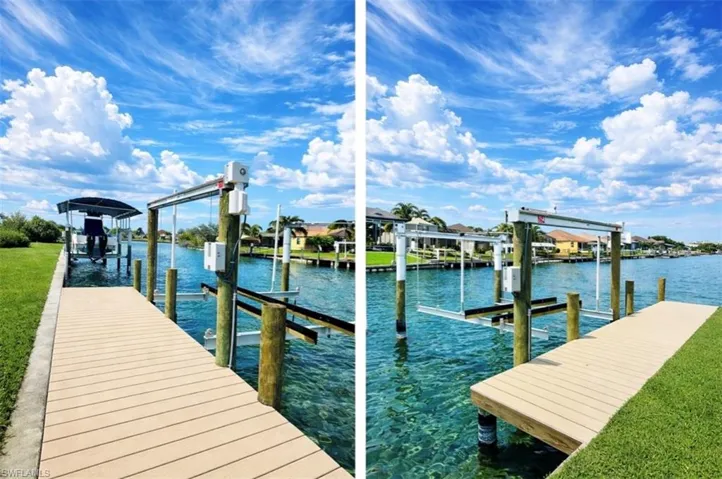 Dock featuring boat lift, a water view, and a yard