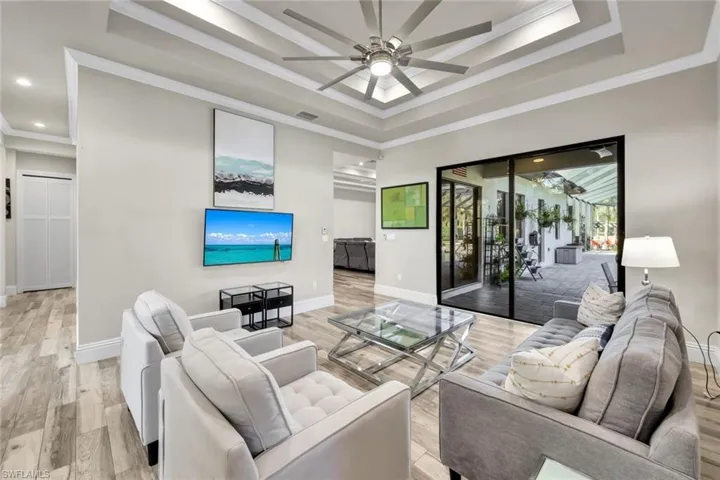 Formal living room features double cove ceilings with crown molding and pool views!