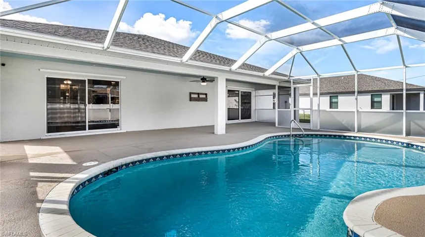 View of swimming pool with a large under truss lanai, and ceiling fan