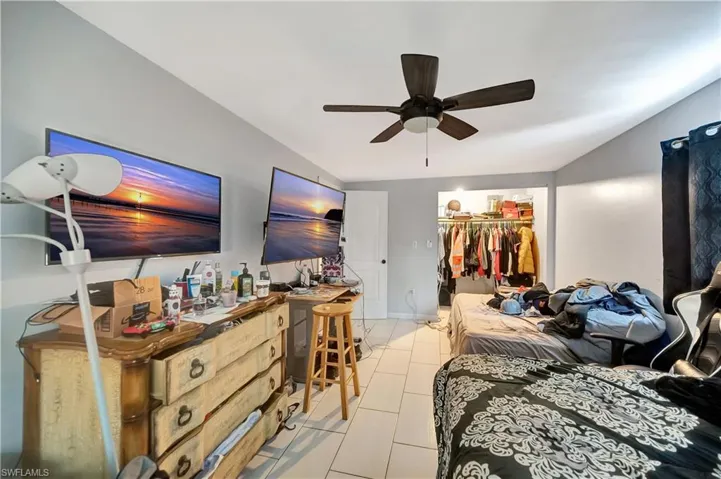 Bedroom featuring light tile patterned floors, a closet, ceiling fan, and a spacious closet