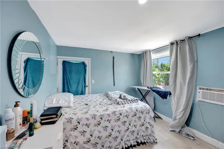 Bedroom featuring a wall mounted AC and light wood-type flooring