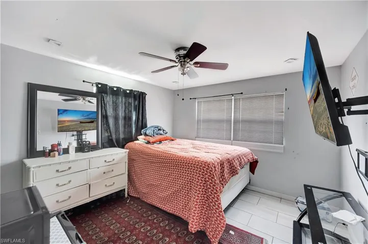 Bedroom with light tile patterned floors and ceiling fan