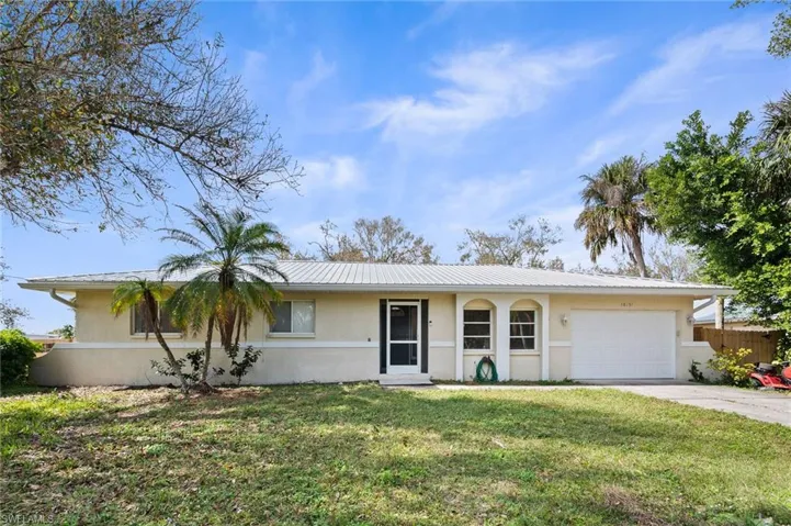 Single story home with a garage and a front yard