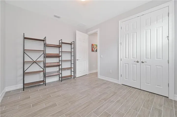 Unfurnished bedroom with light wood finished floors, baseboards, and a closet