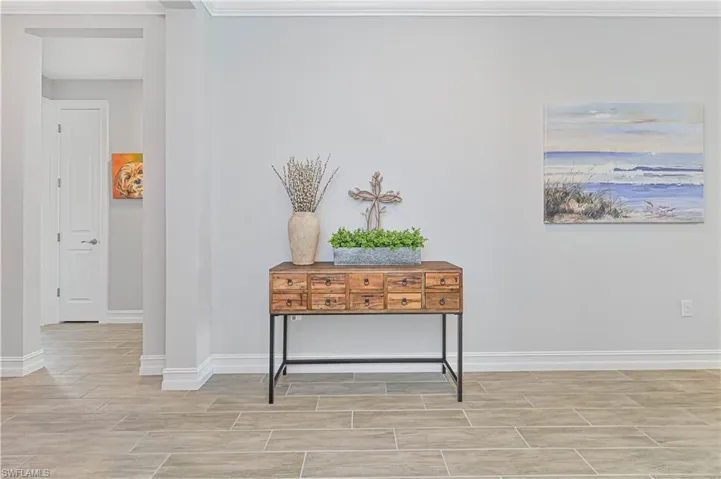 Corridor with wood tiled floors, baseboards, and ornamental molding