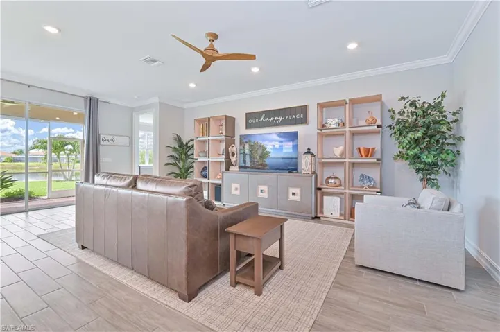 Living area featuring ceiling fan, ornamental molding, recessed lighting, and a water view