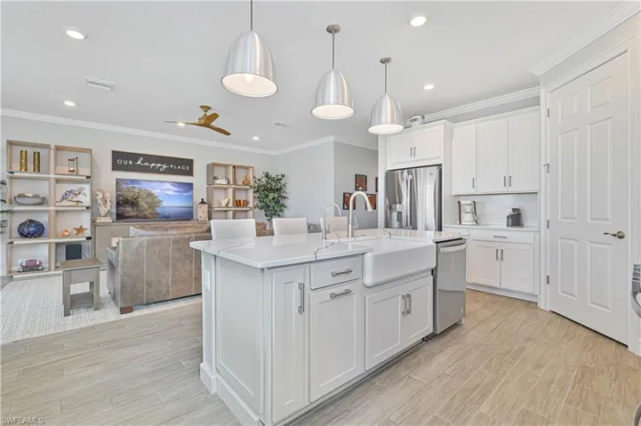 Kitchen featuring appliances with stainless steel finishes, a sink, light countertops, light wood-style flooring, and white cabinets