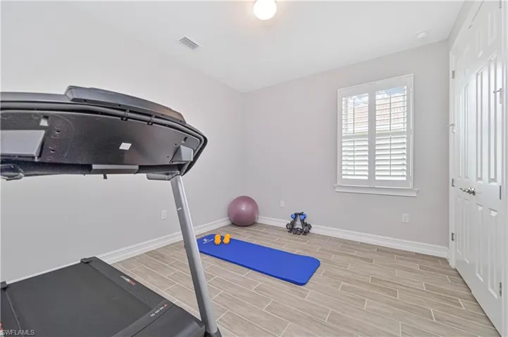 Exercise area with baseboards and wood tiled floors