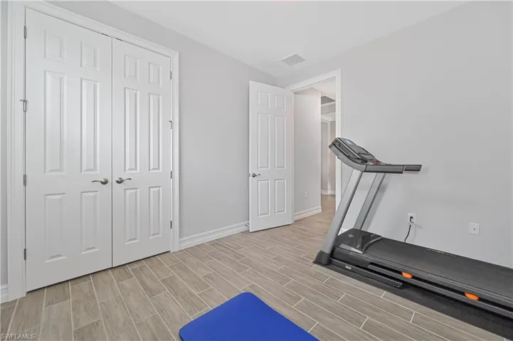 Exercise room featuring light wood-style floors and baseboards