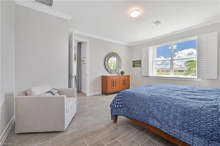 Bedroom featuring crown molding, baseboards, and wood finish floors