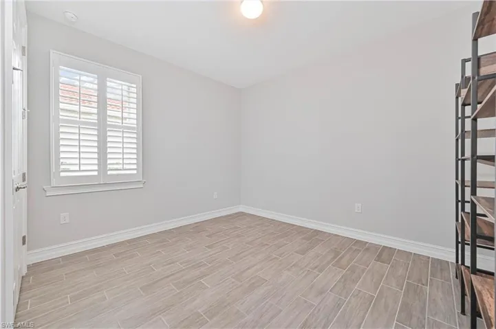Empty room featuring baseboards, light wood-style flooring, and plenty of natural light