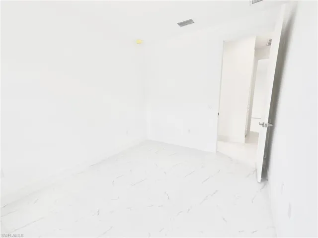 Unfurnished room featuring baseboards and light marble finish floors