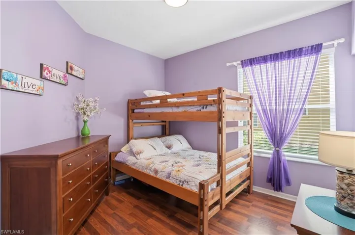 Bedroom featuring dark wood finished floors and baseboards