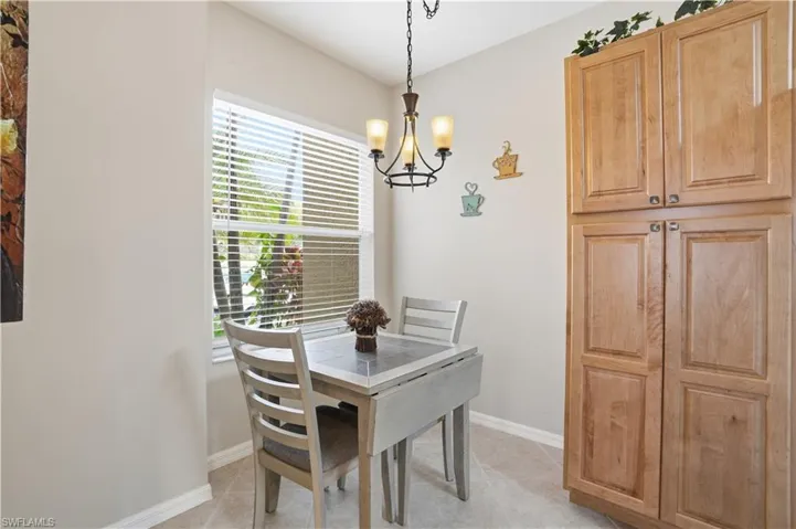 Dining space with suspended lighting and light tile patterned floors