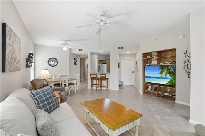 Living area featuring light tile patterned floors and a ceiling fan