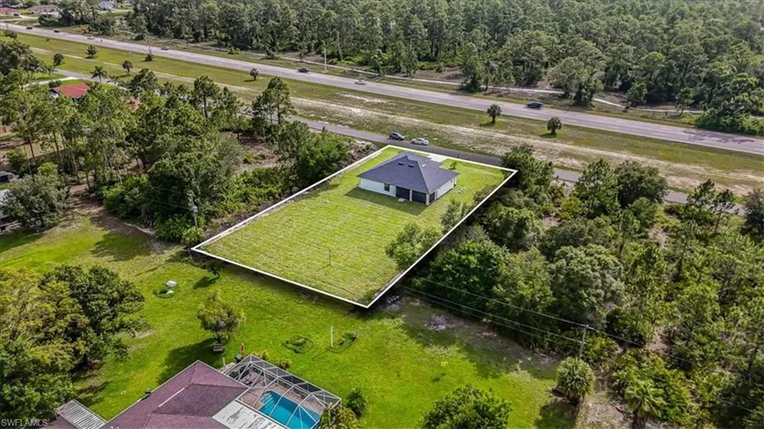 Aerial view of property and surrounding area featuring a pool and property boundaries highlighted