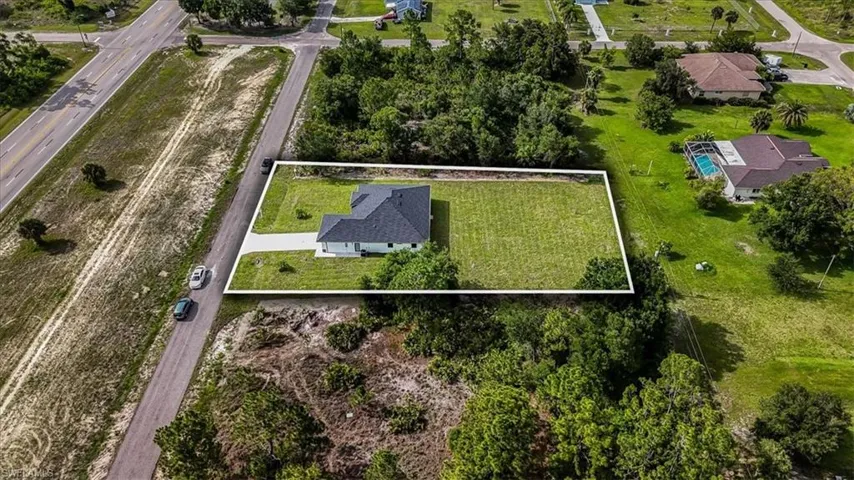 Aerial view of property and surrounding area featuring property parcel outlined
