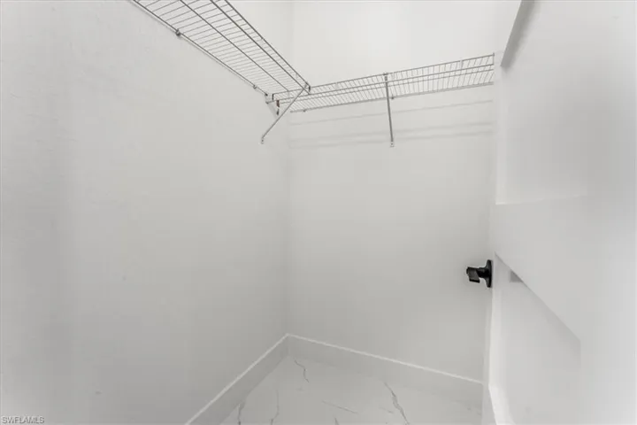 Walk in closet featuring marble finish flooring