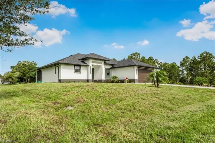 Prairie-style house with stucco siding and a front lawn