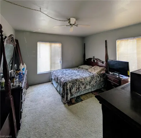 Carpeted bedroom featuring ceiling fan