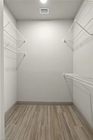 Walk in closet with light wood-type flooring