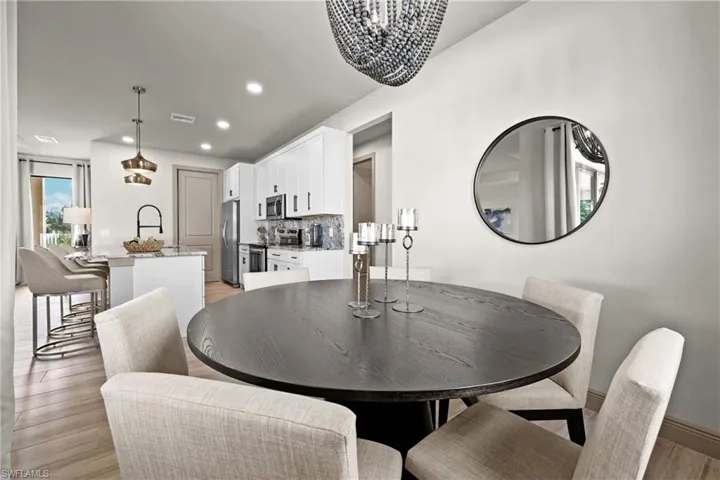 Dining area with light wood-type flooring and a notable chandelier