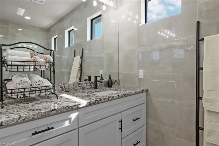 Bathroom featuring vanity and tile walls