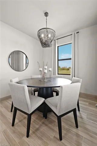 Dining room with light hardwood / wood-style floors and a chandelier