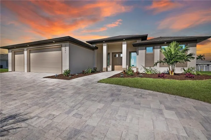 Prairie-style home with a garage and a lawn