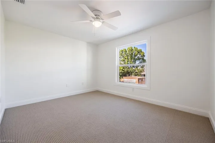 Carpeted spare room featuring ceiling fan