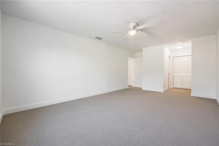 Carpeted empty room with ceiling fan