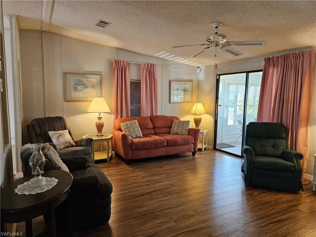 Living area with ceiling fan and wood finished floors